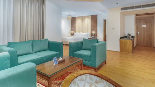 A Spacious living room featuring plush teal coloured sofas - Sarovar Premiere, Srinagar